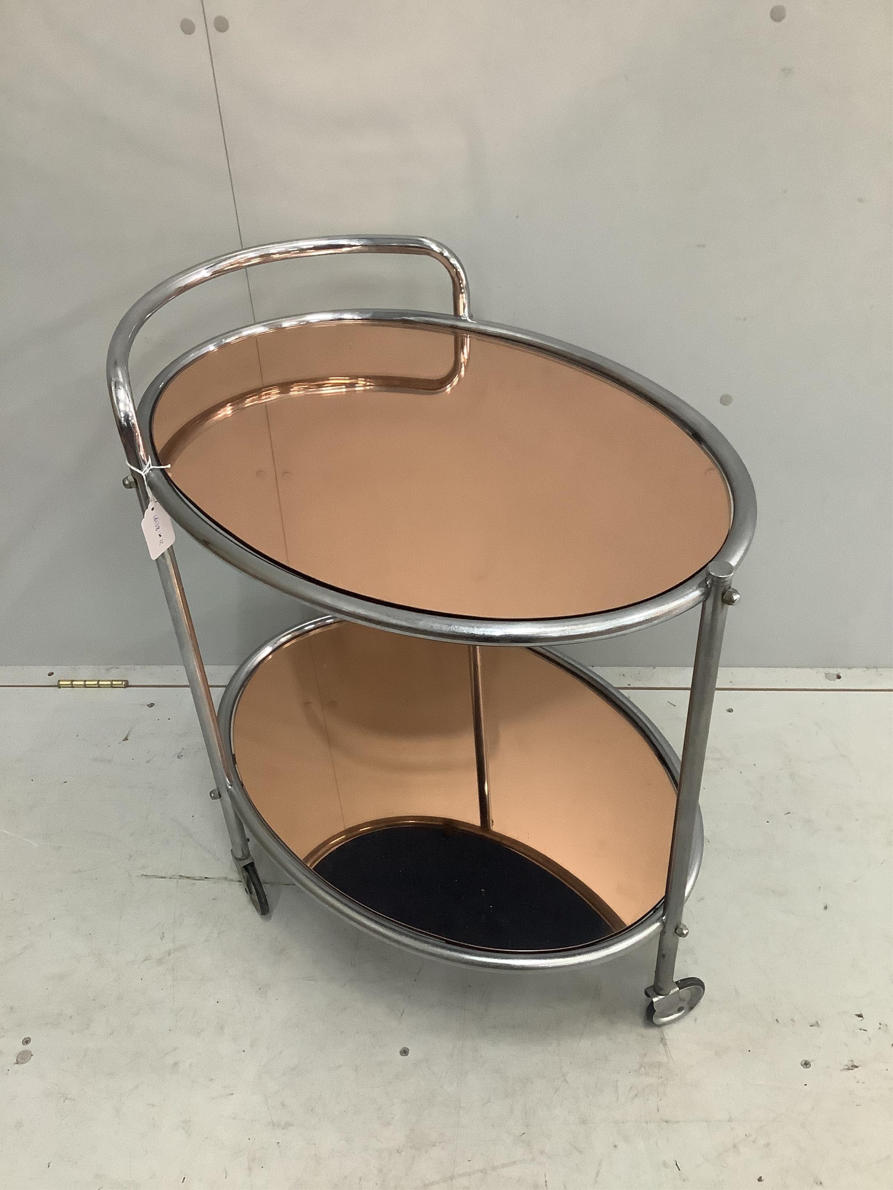 A mid century chrome and peach glass oval two tier drinks trolley, width 66cm, depth 47cm, height 73cm. Condition - fair